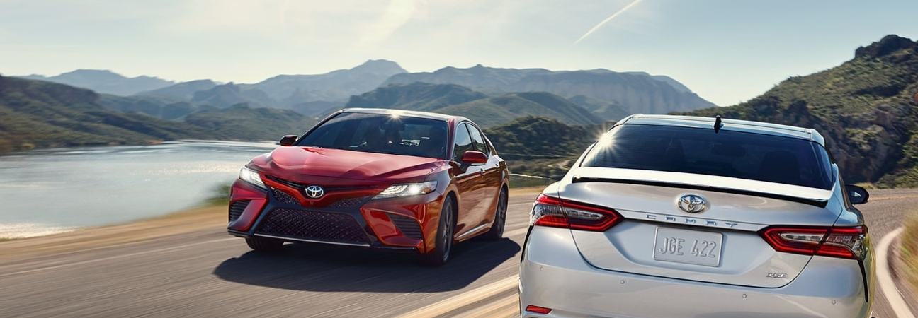 Two 2018 Toyota Camry models passing each other on the road featured in a blog post about used Toyota Camry and Corolla cars