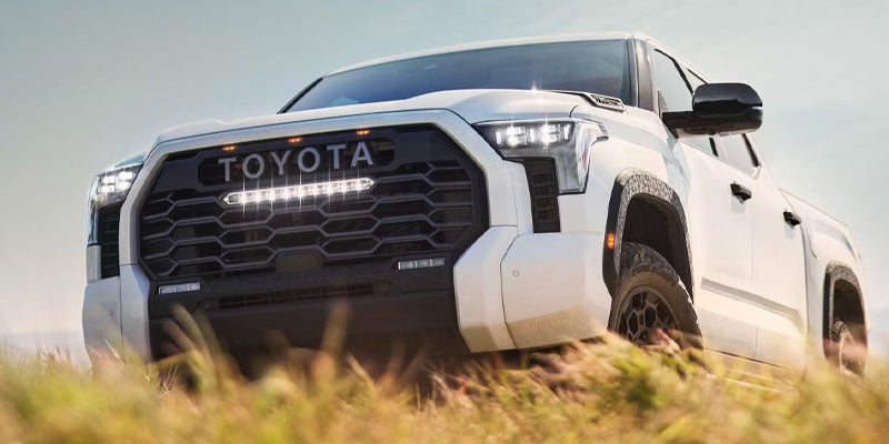 A white Toyota Tundra pickup truck parked on a paved surface, showcasing its sleek design and robust build.